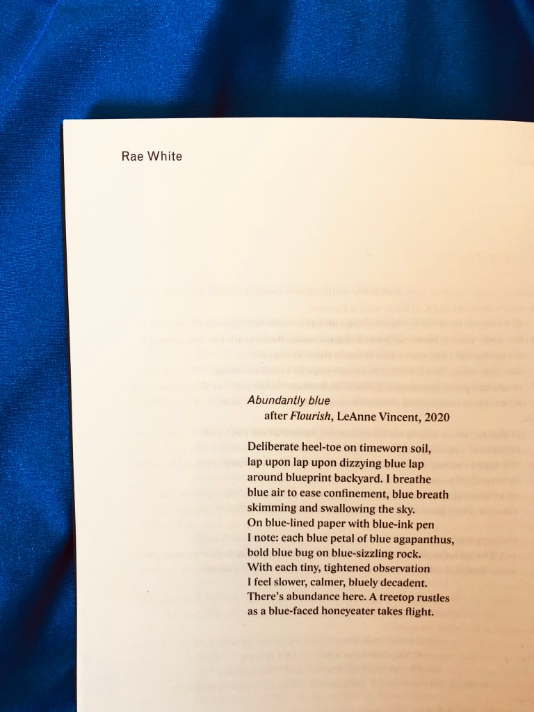 A photo of a page on a blue background with the text of a poem reading, ‘Abundantly blue / after FLOURISH, Leanne Vincent, 2020. Deliberate heel-toe on timeworn soil, lap / upon lap upon dizzying blue lap / around blueprint backyard. I breathe / blue air to ease confinement, blue breath / skimming and swallowing the sky. / On blue-lined paper with blue-ink pen / I note: each blue petal of blue agapanthus, / bold blue bug on blue-sizzling rock. / With each tiny, tightened observation / I feel slower, calmer, bluely decadent. / There’s abundance here. A treetop rustles / as a blue-faced honeyeater takes flight.’